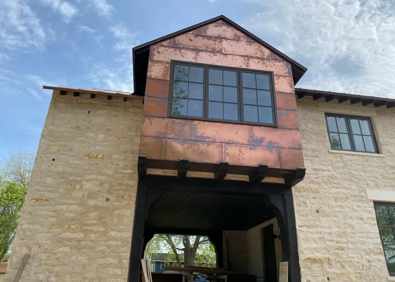 Copper metal panel facade on a stone building for Roof Repair in Highland